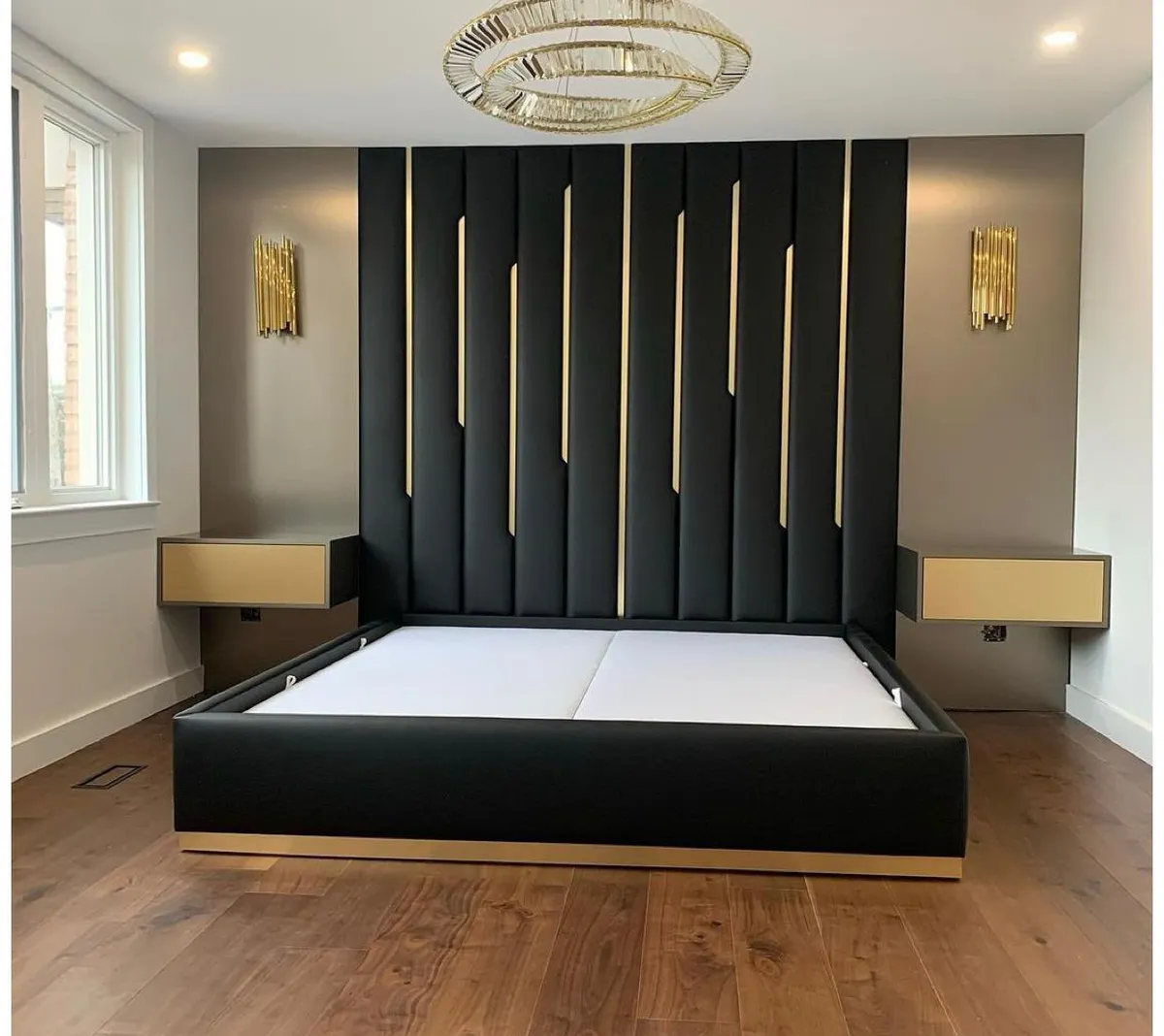Master bedroom with black upholstered wall panels and brass detailing