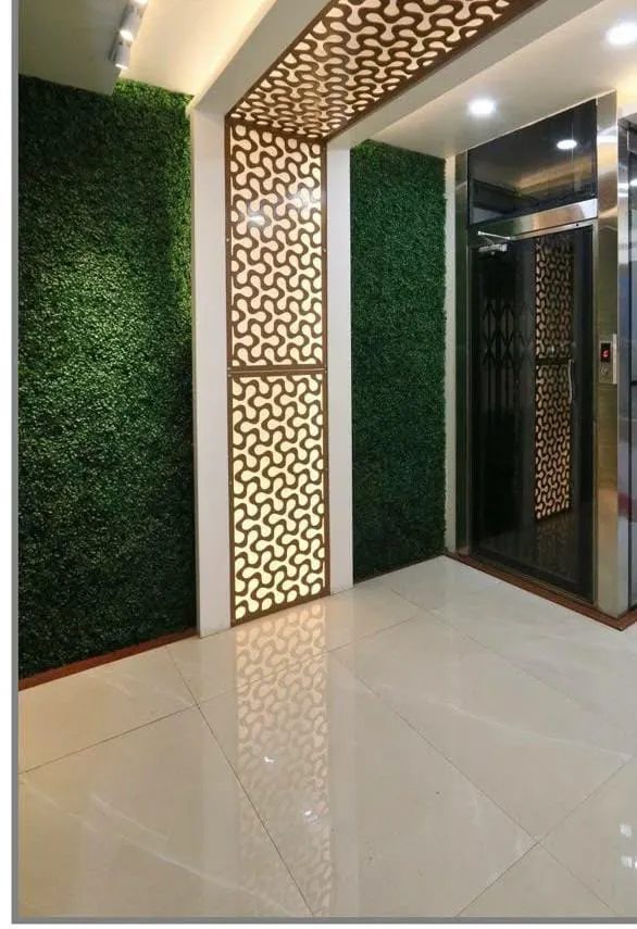 Lift lobby with green wall and laser-cut jaali panels