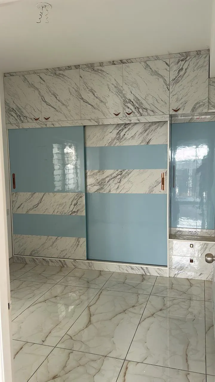 Sliding wardrobe in marble laminate and powder blue